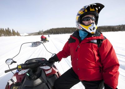 person standing beside a snow mobile