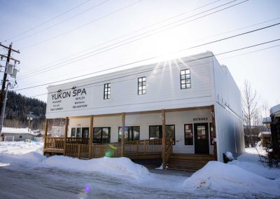 white, wooden building on a snow-covered road