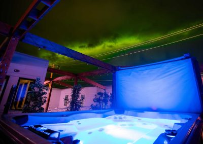 aurora borealis in the night sky, lighted jacuzzi on the foreground